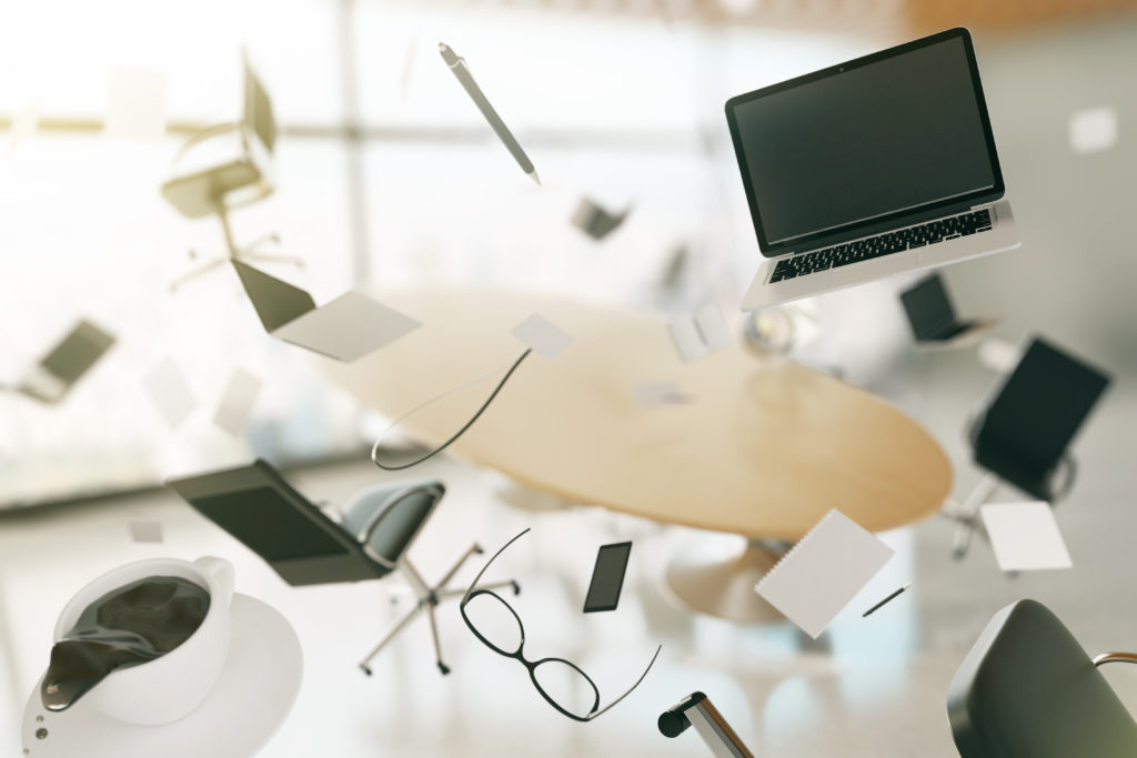 Concept of chaos in a modern office, with flying computers, chai