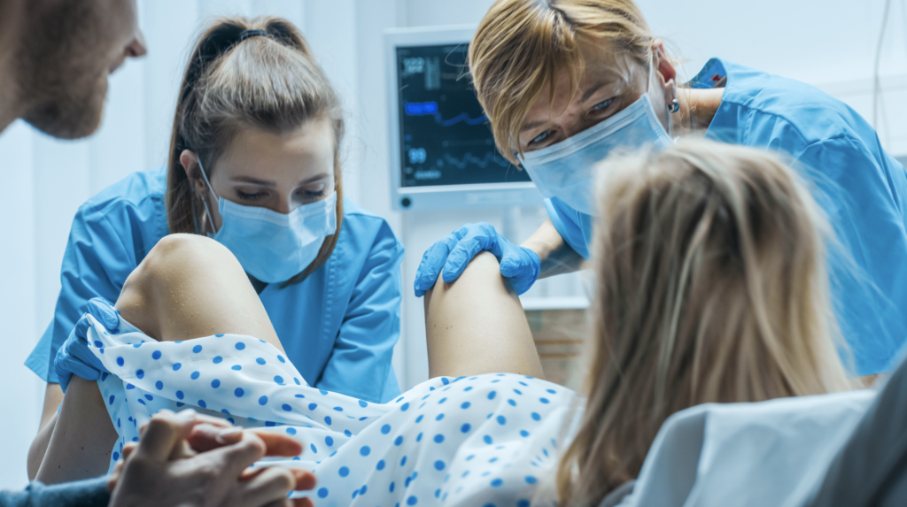 Nurse and midwife help deliver a baby