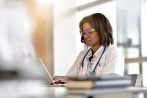 A doctor is participating in a virtual advisory board during her lunch break