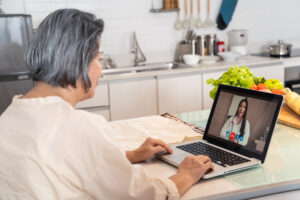 An Asian woman in her 60s is attending a telemedicine appointment