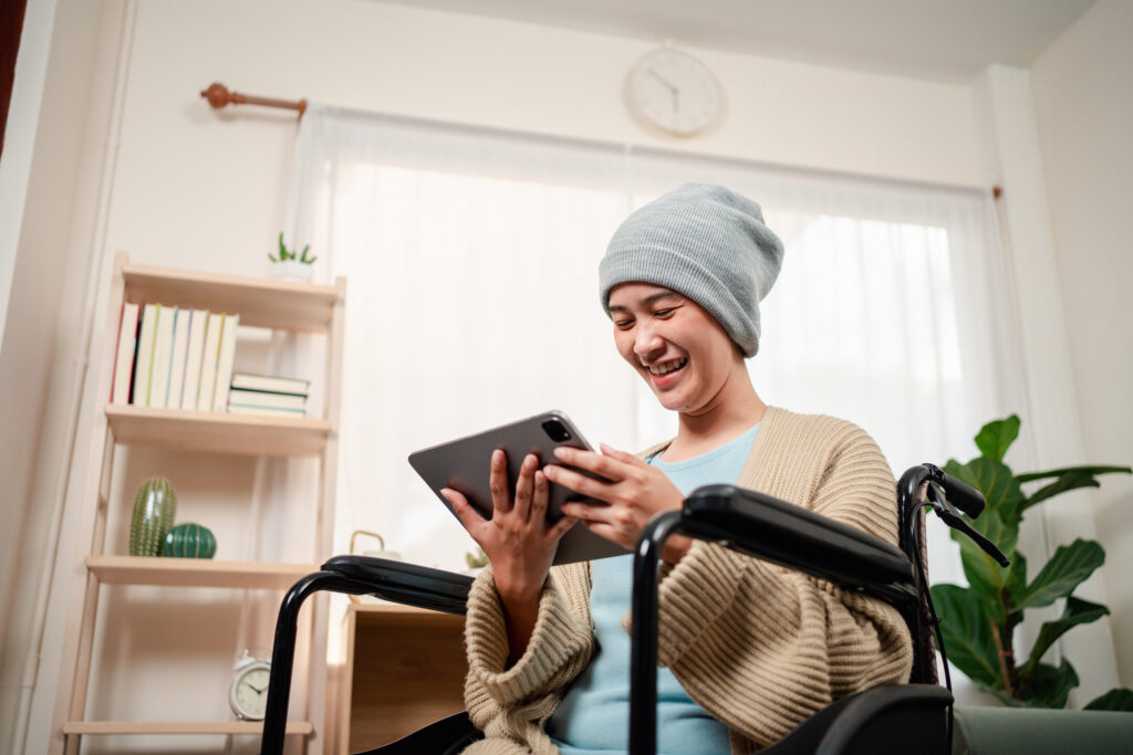 A patient undergoing cancer therapy looking at a tablet, accessing digital tools to help with their cancer journey