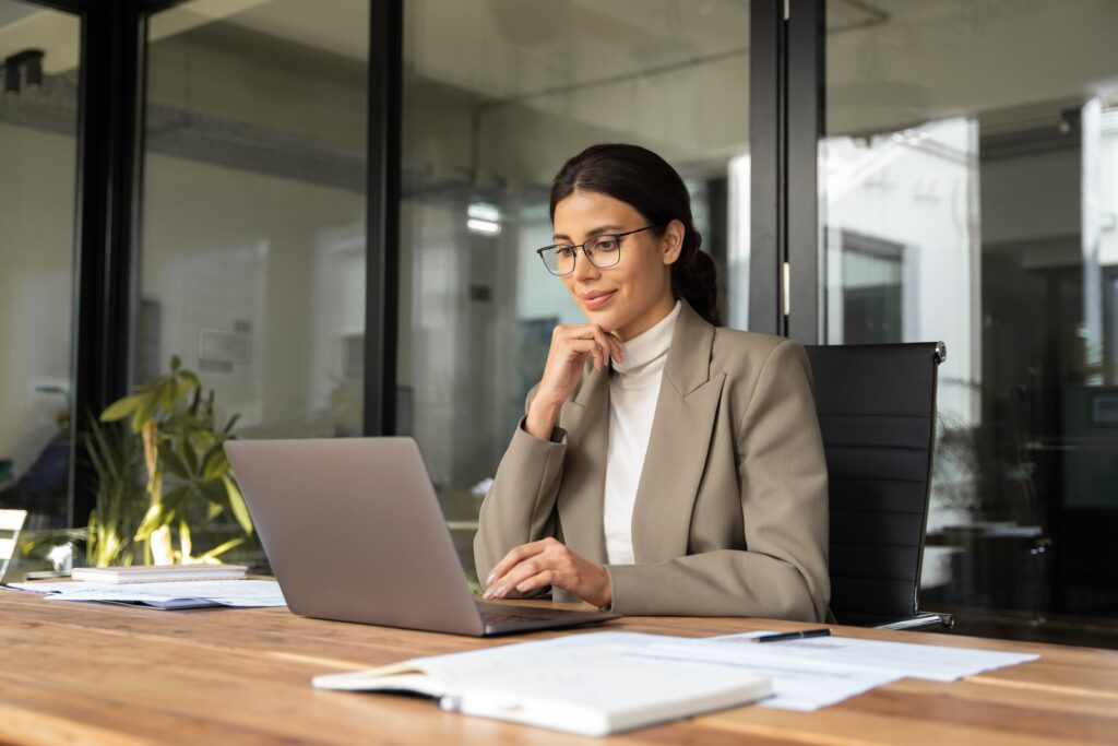 A woman it sitting at her desk with a laptop; digital technologies are the future of MSL training.