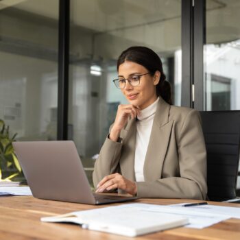 A woman it sitting at her desk with a laptop; digital technologies are the future of MSL training.