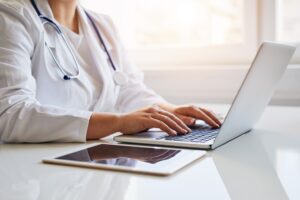 A physician is using a laptop to participate in an asynchronous advisory board on the Impetus InSite Platform.